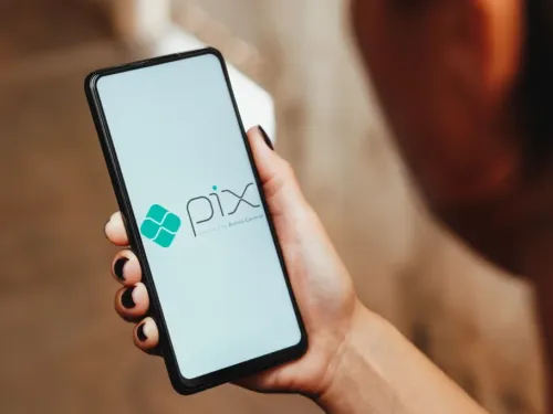 Smartphone com o logo do Pix na tela, segurado por uma pessoa.